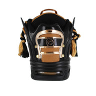 Black and gold sneaker with braided details on a white background