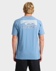 Person wearing a blue Quiksilver t-shirt with a logo on the back against a white background