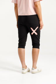 Lady wearing Home-Lee 3/4 Apartment Pants in Black with Blossom Berry X on a white background