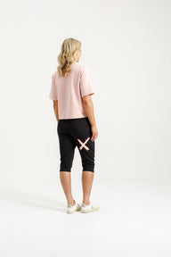 Lady wearing Home-Lee 3/4 Apartment Pants in Black with Blossom Berry X on a white background