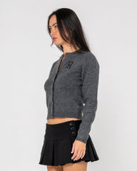 Woman wearing a gray cardigan and black skirt on a white background