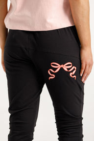Lady wearing Home-Lee Apartment Pants with pink Bow and white background