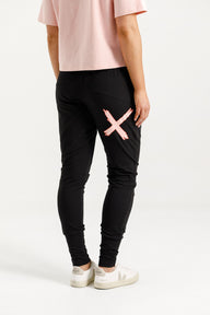 Person wearing Home-Lee Apartment Pants black with a pink 'X' design on a white background