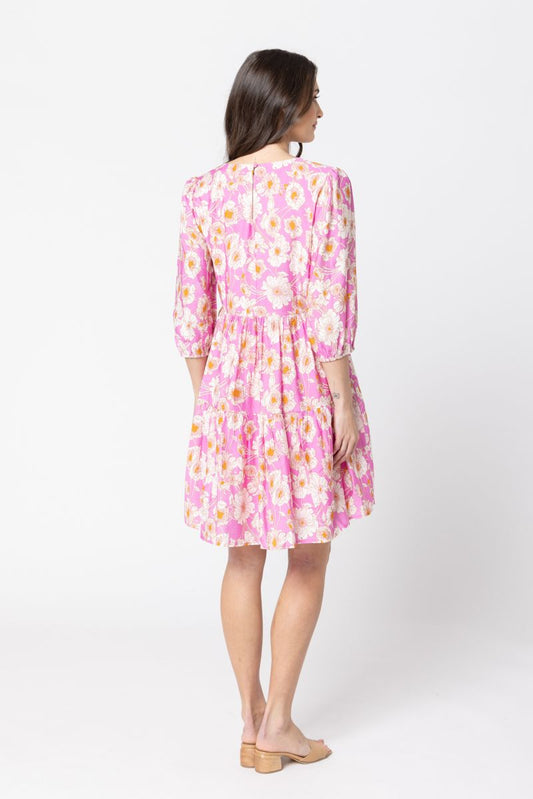 Woman wearing a pink floral dress on a white background