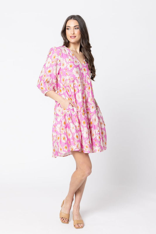 Woman wearing a pink floral dress on a white background