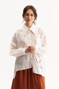 Woman wearing a white lace top and brown skirt on a white background