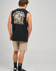 A man wearing a black sleeveless muscle tank top with a large graphic print on the back, paired with beige shorts, black socks, and black sneakers, photographed from behind against a light gray studio background.