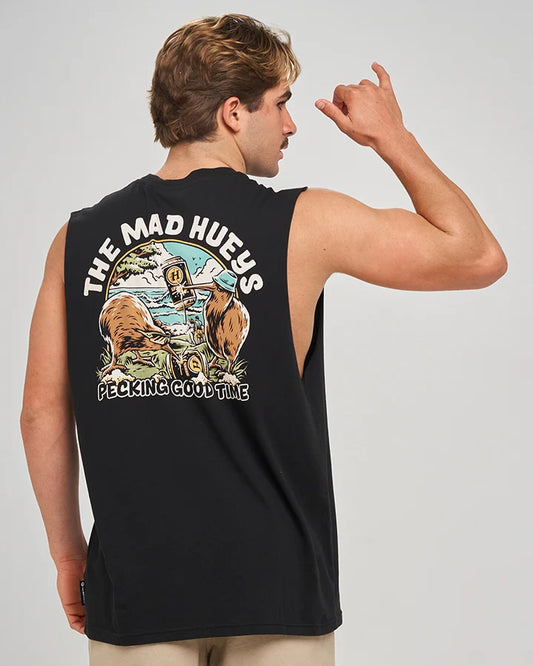 A man shown from the back wearing a black sleeveless muscle tank top with a large graphic print on the back. The graphic features the text 'THE MAD HUEYS' and 'PECKING GOOD TIME' with an illustration of a bear, a person, and a mountain landscape.