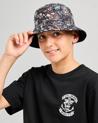 Person wearing a black t-shirt with a graphic design and a patterned bucket hat.
