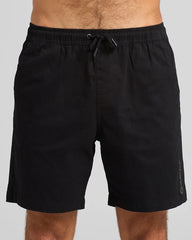 Black shorts worn by a person on a gray background