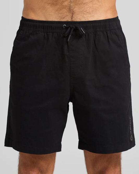 Black shorts worn by a person on a gray background