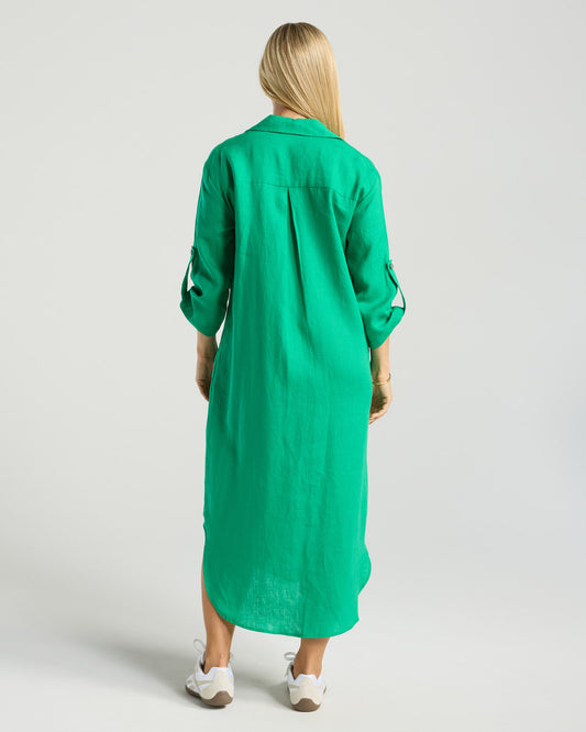 Person wearing a green dress with long sleeves on a plain background