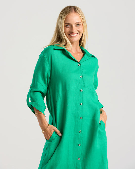 Woman wearing a green dress with a plain background