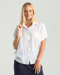 Woman wearing a white blouse with short sleeves on a plain background