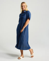 Woman wearing a blue dress on a light gray background