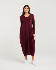 Woman wearing a burgundy dress on a white background