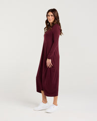 Woman wearing a burgundy dress on a white background