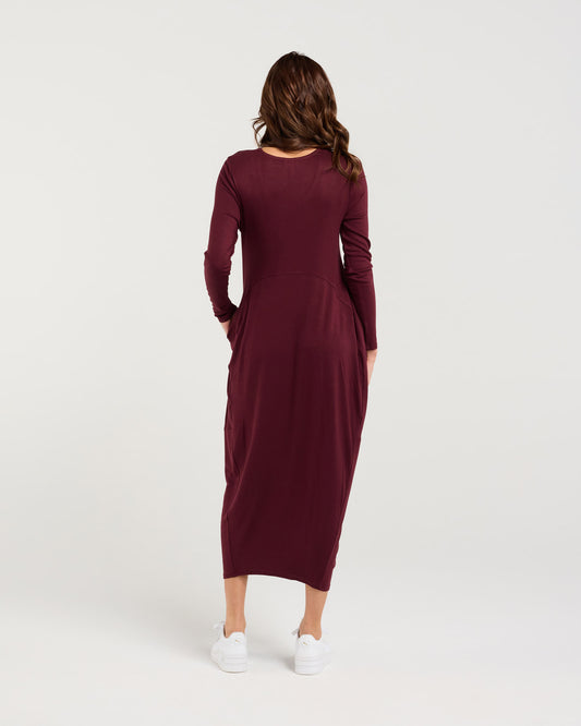 Woman wearing a burgundy dress on a white background