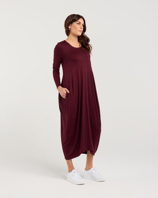 Woman wearing a burgundy dress on a white background