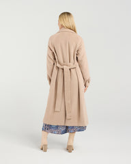 Woman wearing a beige coat on a white background