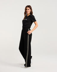 Woman wearing a black outfit with a brand logo on a white background