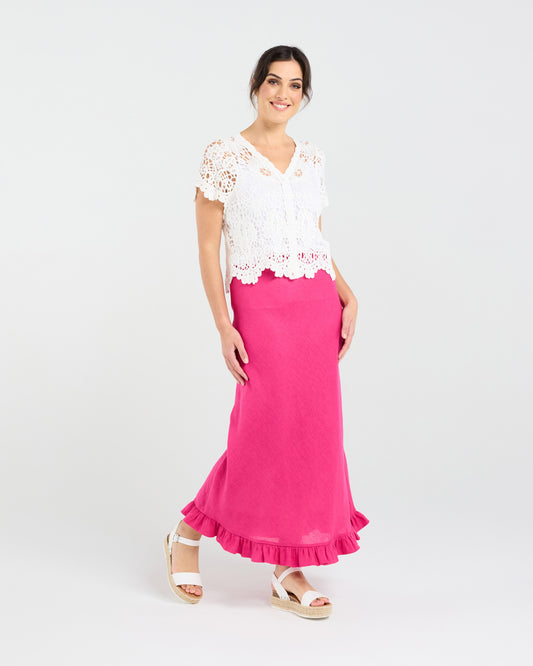 Woman wearing a white lace top and pink skirt on a white background