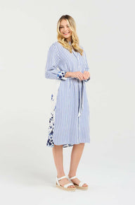 Woman wearing a blue and white striped dress with a floral pattern on a white background