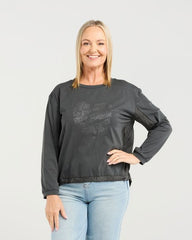 Woman wearing a dark gray sweatshirt and light blue jeans on a white background