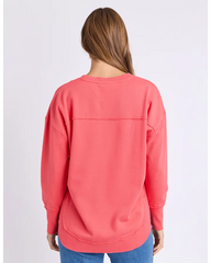 Person wearing a coral sweatshirt on a light gray background
