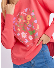 Red sweatshirt with floral design and 'FOXWOOD' branding worn by a person.