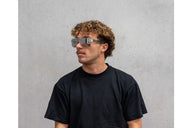 Man wearing futuristic goggles against a gray background