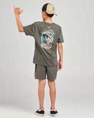 Child wearing a graphic t-shirt and shorts with a cap, standing against a plain background