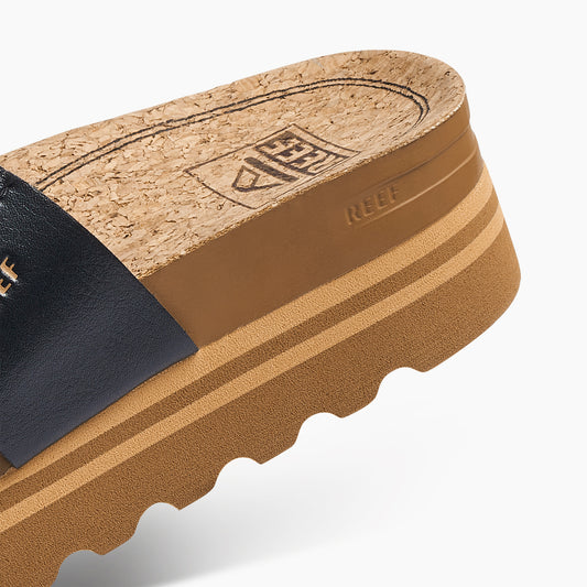 Close-up of a sandal with cork insole and black leather strap on a white background