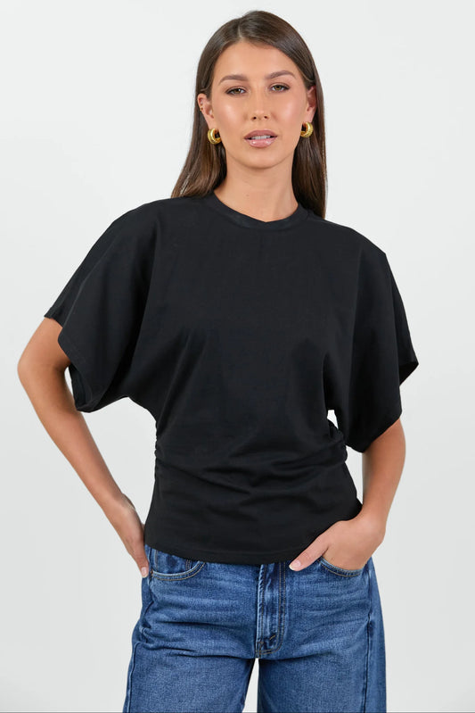Woman wearing a black oversized t-shirt and blue jeans on a white background