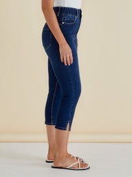 Person wearing blue jeans on a beige background