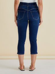 Person wearing blue jeans on a beige background