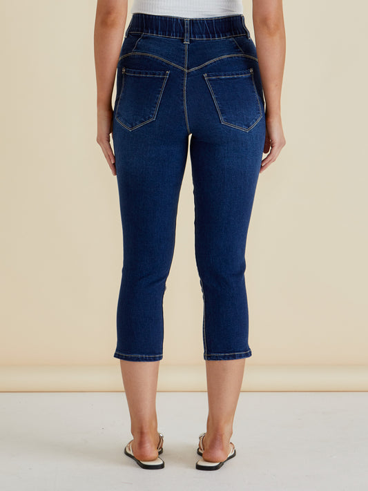Person wearing blue jeans on a beige background