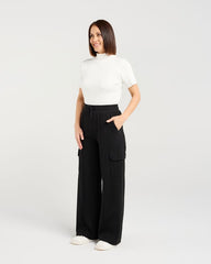 Woman wearing a white top and black wide-leg pants on a white background
