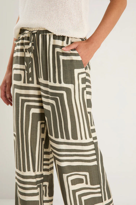 Person wearing patterned pants with a plain background