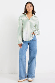 Woman wearing a striped shirt and blue jeans on a white background