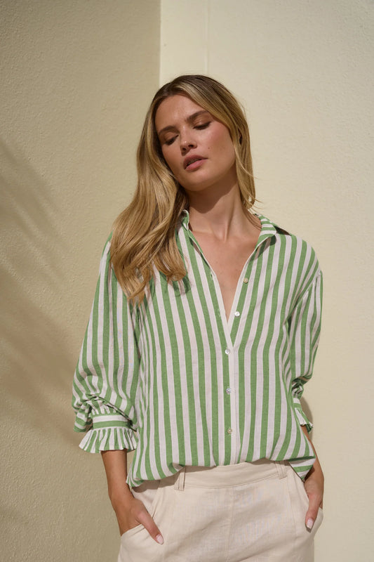 Woman wearing a green and white striped shirt against a beige background