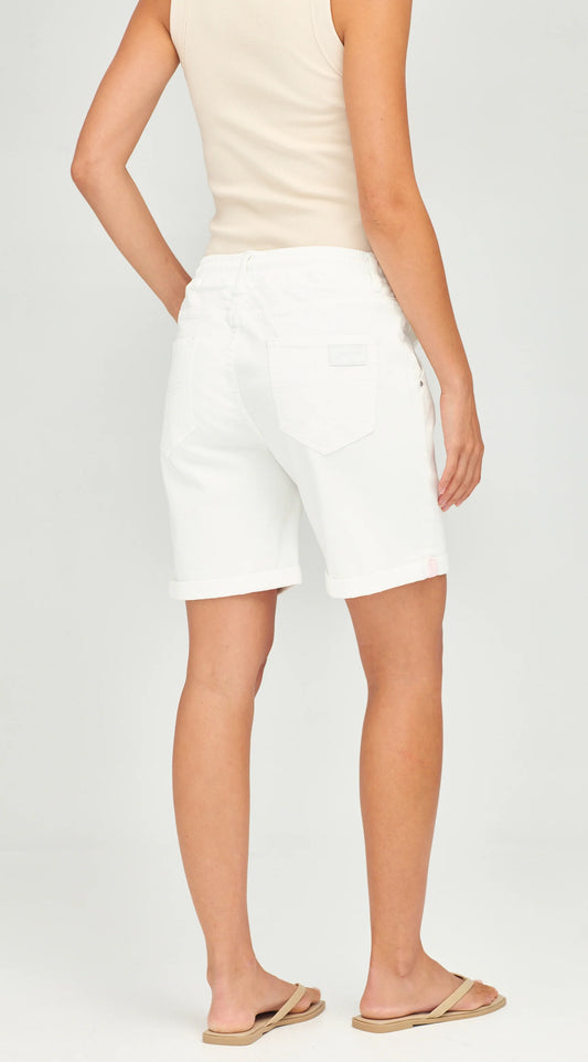 A model shown from the back wearing white denim shorts, a light beige tank top, and tan flip-flops against a light gray studio background.