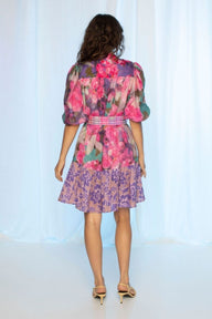 Woman wearing a colorful floral dress against a white background