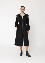 Woman wearing a black coat with a white background