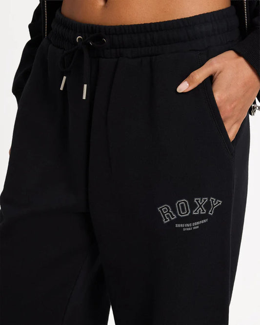 Black sweatpants with 'ROXY' branding on a plain background