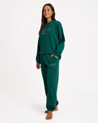 Woman wearing a green sweats with a plain background