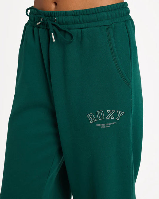 Green sweatpants with 'ROXY' branding on a white background