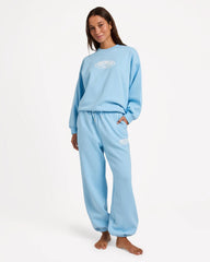 Person wearing a light blue sweatshirt and pants set on a white background