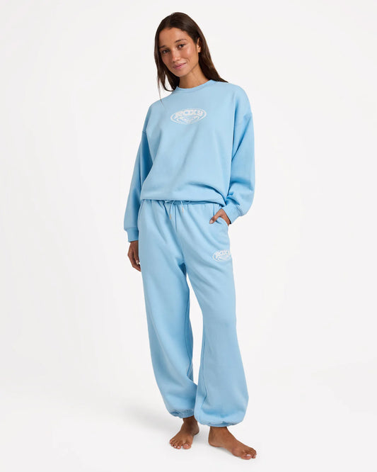 Person wearing a light blue sweatshirt and pants set on a white background