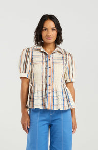 Woman wearing a plaid shirt and blue pants on a white background